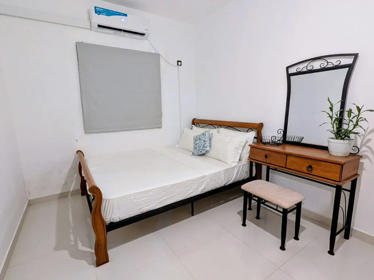 Air-conditioned main bedroom at Greenview Apartment with queen bed, white bedding and dressing table