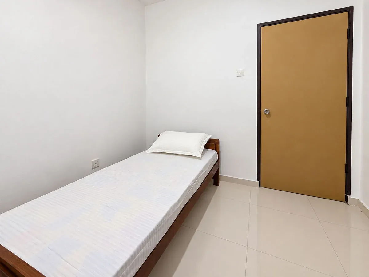 Third bedroom with single bed, white walls and a light wood door