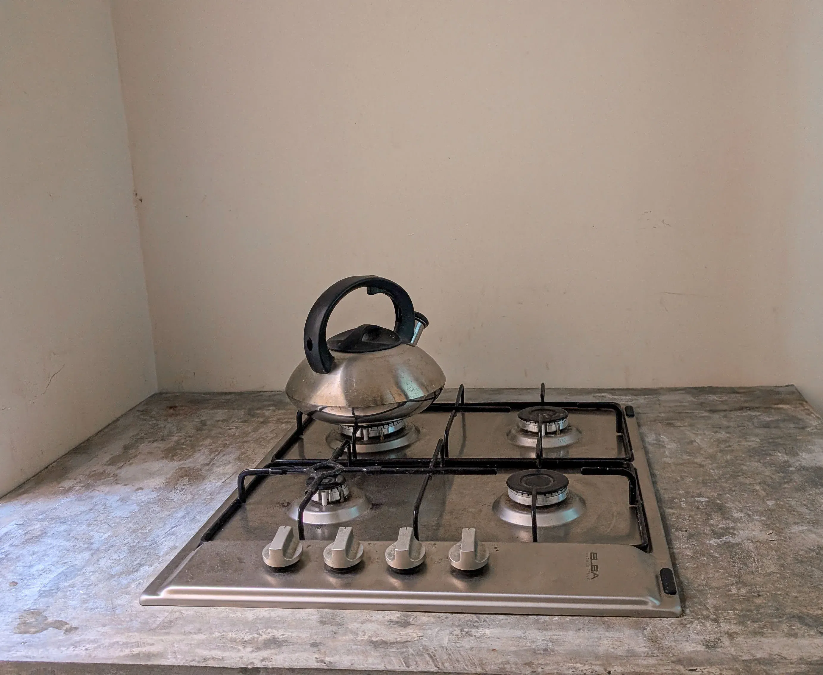 Compact kitchen at Greenview Apartment with stainless steel gas cooker and grey countertops